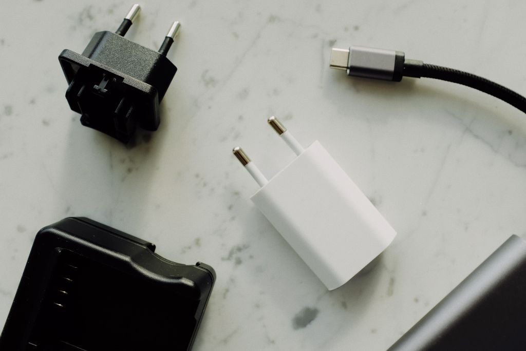 A collection of power adapters and a USB-C charger laid out on a surface