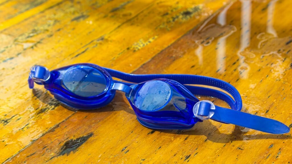 Swimming goggles resting on a poolside deck
