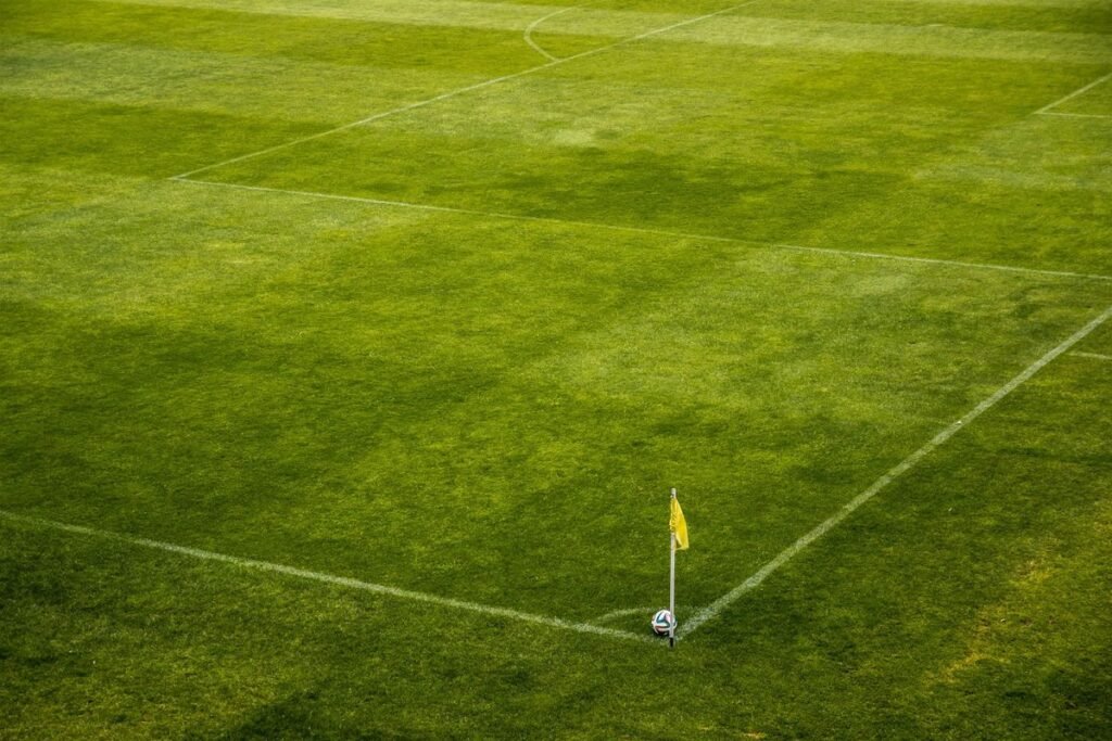 Soccer ball by the corner flag on a green pitch