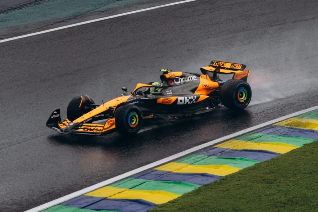Formula 1 Team Polos for Race Weekend Watch Parties Modern Formula 1 car in papaya orange racing on a wet track