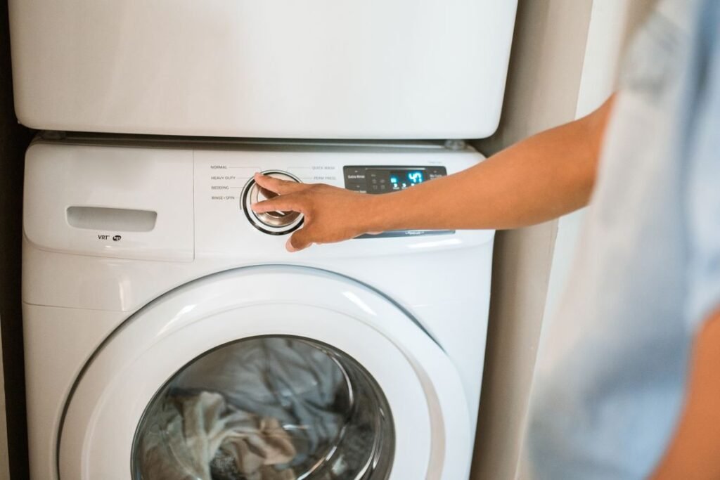 White front load washing machine with its cycle dial and digital display being set