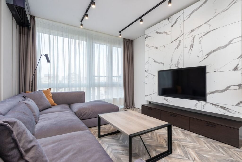 Large flat screen television wall mounted above a media unit in a living room