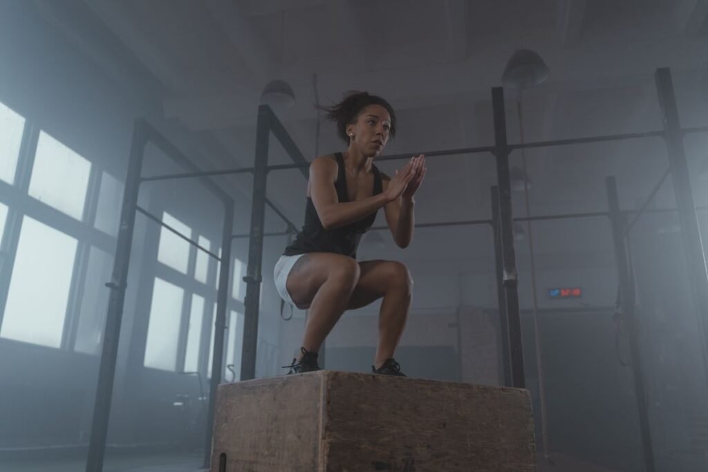 Athlete landing a box jump in a gym