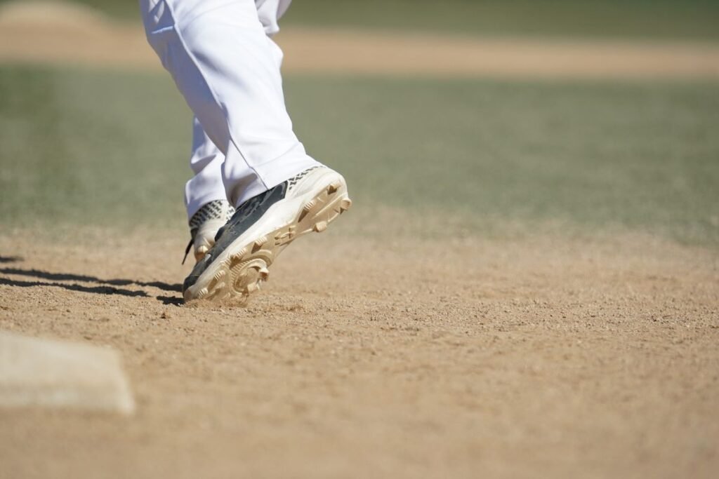 Molded baseball cleats pushing off the infield dirt