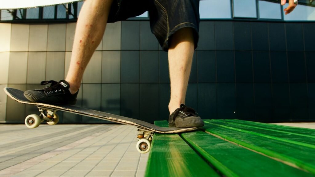 Black skate shoes on a skateboard deck