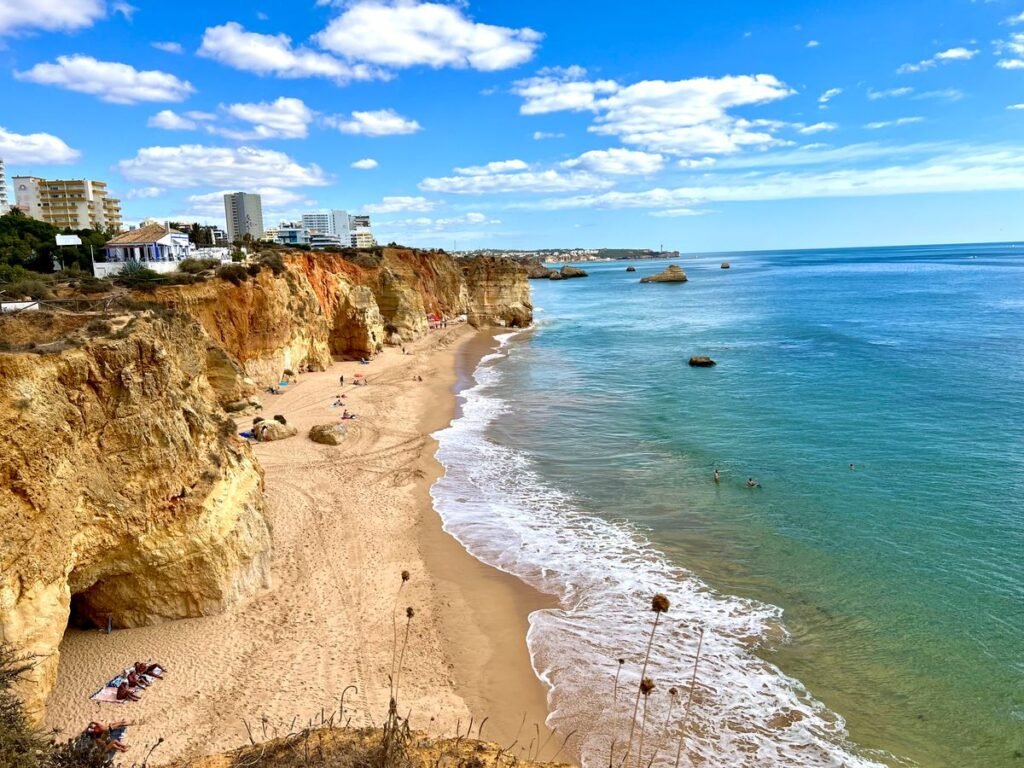 Ochre cliffs above a sandy Algarve beach and turquoise water