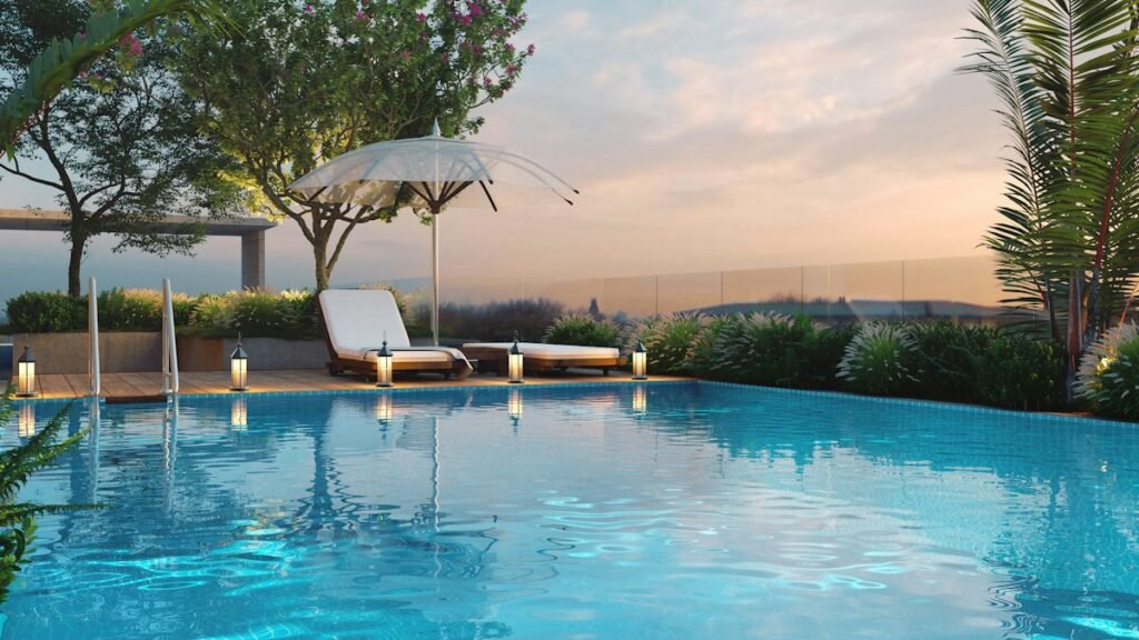 Resort pool with loungers and a parasol at dusk